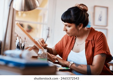 Woman, painting and artist with easel in process of creativity at studio with project inspiration. Painter, working and sketch with brush on cavas in workshop with talent and skill in watercolor art - Powered by Shutterstock