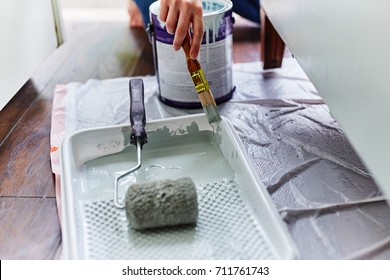 Woman Painting A Cabinet With Brush