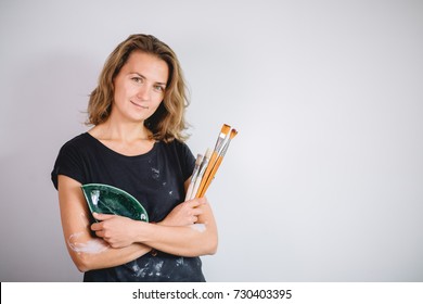 Woman Painting Clay Pot With Senior Potter At Workshop