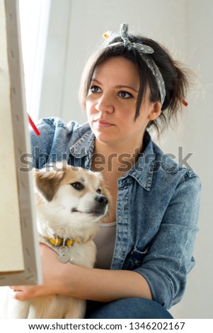 Woman painting with cute little dog