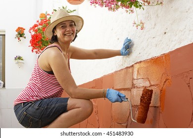 Woman Painting Exterior Home