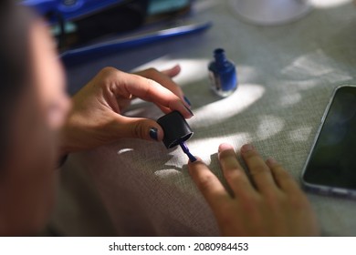 Woman Painting Her Nails Blue In Detail Shot