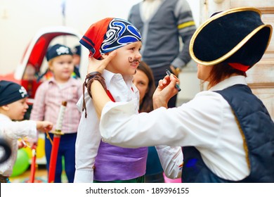 Woman Painting Kid's Face On Party