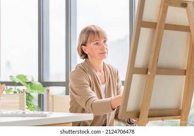 Woman Painting On A Canvas, Mature Middle Aged Woman Painting On Canvas At Home, Happy Retirement Concepts