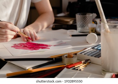 Woman painting a picture with a brush. Learning to draw at home. Autor Creating content concept.