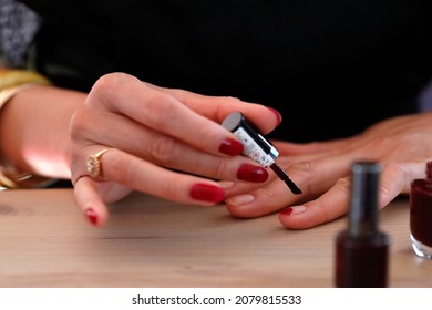 Woman Painting Red Nail Varnish On Her Nails.   France. 