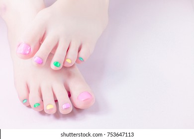 Woman Painting Toe Nails Own With Manicure Multi Colored Nail Polish Gel. Fingernail Paint,colorful In The Bottle For Beautiful Feet . Customise Sweet Candy Pastel Bright Colors Tone .