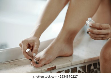 Woman Painting Toenails on Bathroom Edge - Powered by Shutterstock