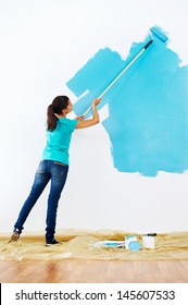 Woman Painting Wall In New Home