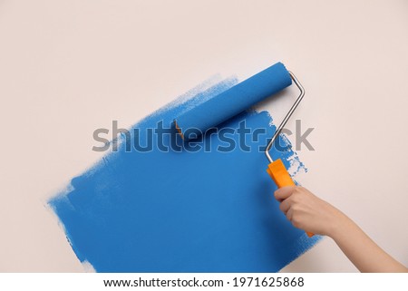 Woman painting wall with roller, closeup. Redecoration Imagine de stoc © 