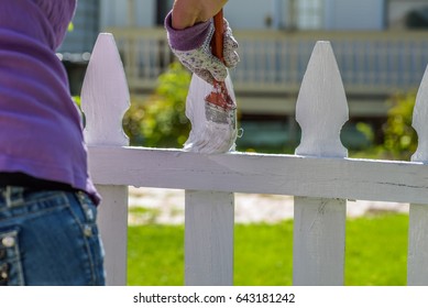 Woman Painting White Picket Fence On Sunny Day- Hands Only, Soft Focus