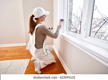 Woman Painting Window Trim