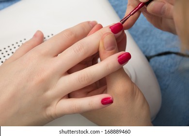 woman paints her nails painted ruby