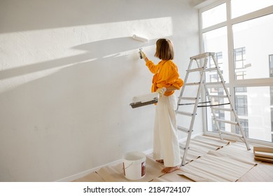 Woman paints the wall in white color while making repairment in newly purchased apartment. Repair and house renovation concept - Powered by Shutterstock