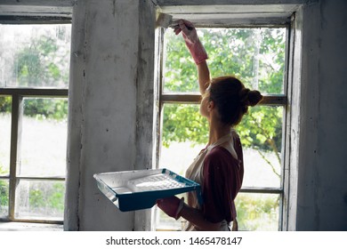 woman paints a window in white repair - Shutterstock ID 1465478147