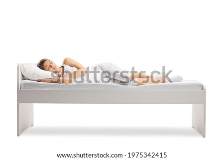 Woman in pajamas sleeping on a bed isolated on white background