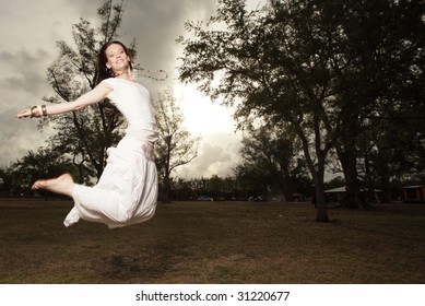 Woman in the park jumping for joy