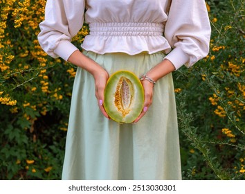 woman in park posing with melon,holding fruit on eyes or below waist.girl with picnic accessories, autumn fruit as strawberry.female drinking tea,pouring from vintage kettle.bush with yellow berries. - Powered by Shutterstock