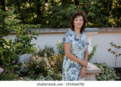 Woman In Park.. Senior Working In Garden. Close-up Portrait Of An Older Woman On Walk With Flowers. Park.