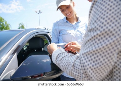 Woman In Parking Lot Renting Car From Rental Company