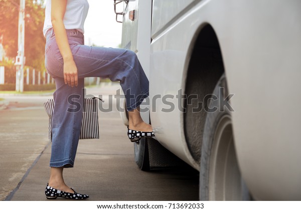 Woman passenger with\
getting on the bus
