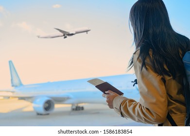 woman passenger holding in hand passport and boarding pass standing by for boarding in terminal gate, aircraft docking in terminal waiting for services under schedule time - Powered by Shutterstock