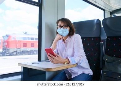 Woman Passenger In Medical Face Mask Is Sitting Inside Train