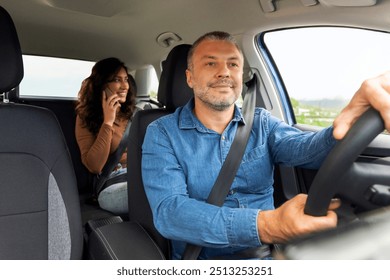 Woman passenger talking on cellphone, sitting on backseat in taxi, smiling driver man riding car holding wheel