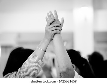 Woman Pastor Pray For Worship Team In Church.Group Of Diverse Hands Holding Each Other And Pray For Support Together.Worship Teamwork And Unity In Church.Black And White Tone.