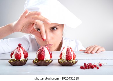 woman pastry chef decorates small strawberry cakes
