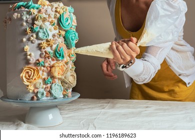 Woman Pastry Chef Decorating A Cake With A Pastry Bag With Cream