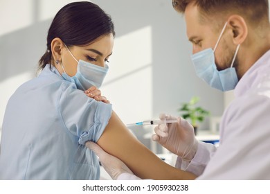 Woman patient giving arm for protection from coronavirus infection and making vaccination injection from doctor in clinic. Vaccine against COVID-19 infection during outbreak - Shutterstock ID 1905930238