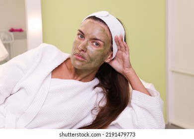 Woman Patient Portrait, Prepared For LED Phototherapy For The Face. Girl With Green Gel With Seaweed Photosensitizer. Facial Care. Light Therapy In Clinic, Anti-age Procedure. Face Closeup