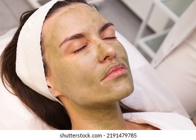 Woman Patient Portrait, Prepared For LED Phototherapy For The Face. Girl With Green Gel With Seaweed Photosensitizer. Facial Care. Light Therapy In Clinic, Anti-age Procedure. Face Closeup