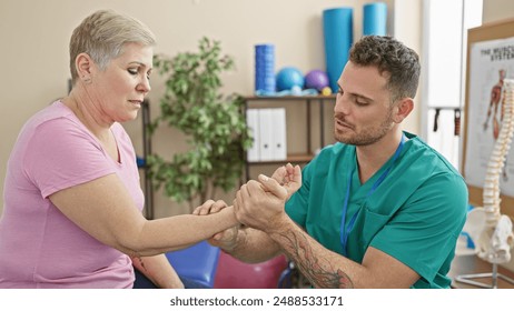 A woman patient receives wrist examination from a man physiotherapist in a rehab clinic interior - Powered by Shutterstock