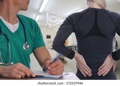 Woman Patient Suffering From Back Pain During Medical Exam By Doctor . Rehabilitation After Sports Exercising Injury. Physical Therapy.