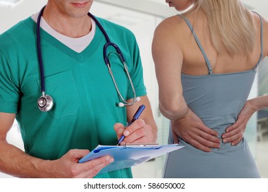 Woman Patient Suffering From Back Pain During Medical Exam By Doctor . Rehabilitation After Sports Exercising Injury. Physical Therapy.