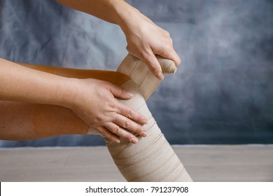 Woman patient with varicose veins applying elastic compression bandage after surgery. Curative treatment, thrombosis prevention and senior health care concept. 