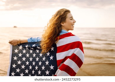 Woman patriot  with american flag on the beach at sunset. USA celebrate 4th of July. Independence Day concept - Powered by Shutterstock