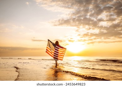 Woman patriot  with american flag on the beach at sunset. USA celebrate 4th of July. Independence Day concept - Powered by Shutterstock