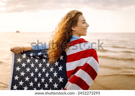 Woman patriot  with american flag on the beach at sunset. USA celebrate 4th of July. Independence Day concept