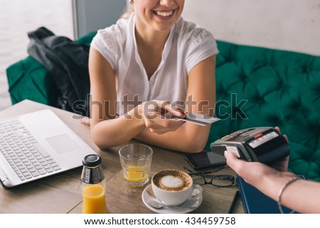 Woman pay with credit card in cafe bar