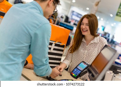 Woman Paying For Apparel In Store