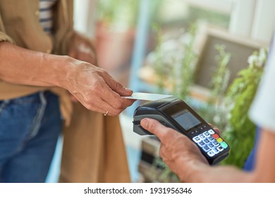 Woman paying with bank card in shop
