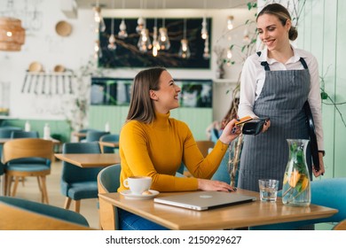 woman paying bill contactless with debit card - Powered by Shutterstock