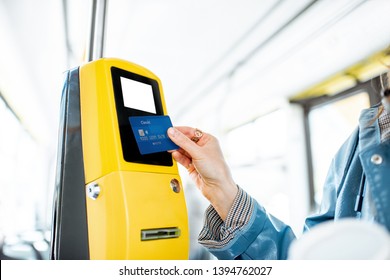 Woman paying conctactless with bank card for the public transport in the tram