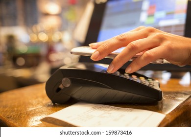 Woman Paying With NFC Technology On Mobile Phone, Restaurant, Cafe, Bar