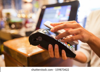 Woman Paying With NFC Technology On Mobile Phone, Restaurant, Cafe, Bar