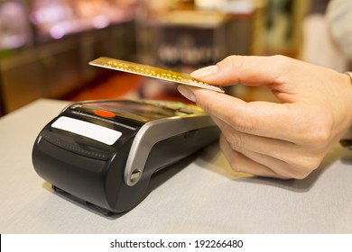 Woman Paying With NFC Technology On Credit Card In Supermarket