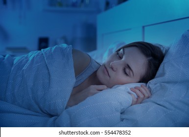 Женщина мирно спит в постели ночью